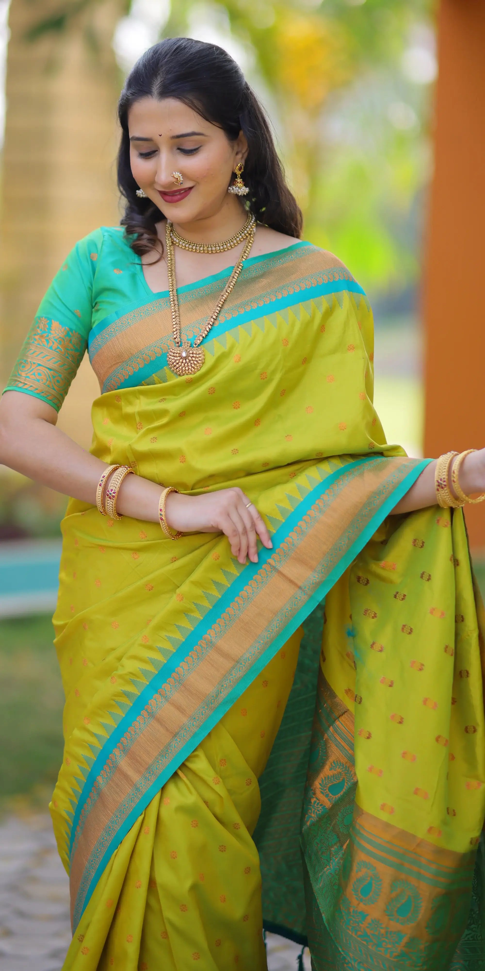 Woman wearing a bright yellow saree with green border outdoors